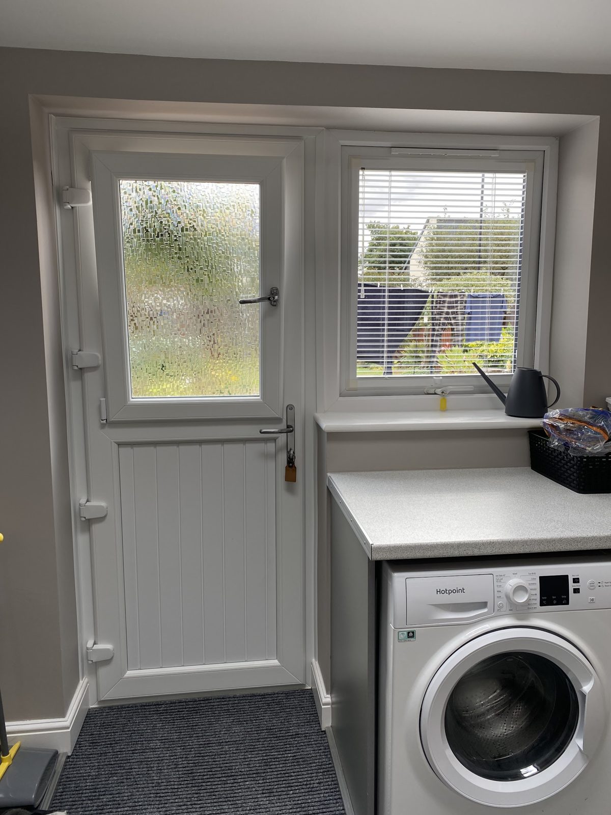 White half-glazed back door and matching window fitted in a utility room