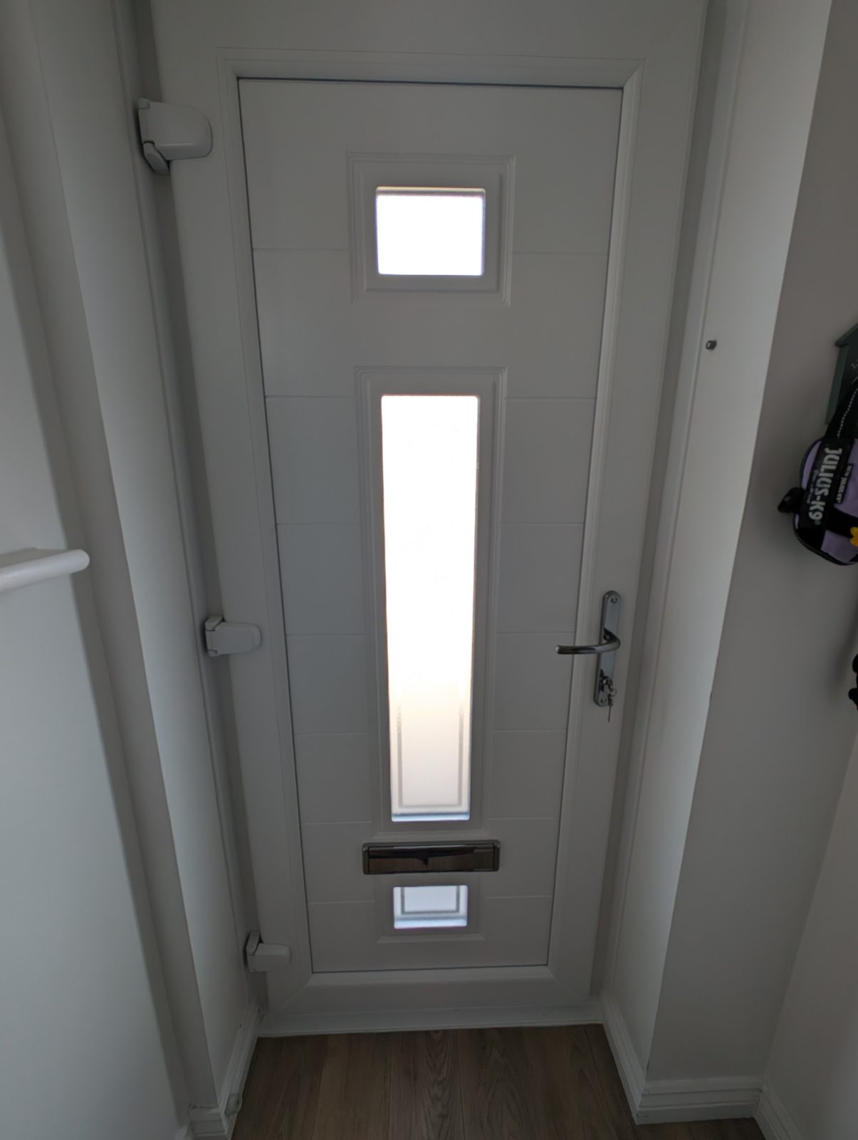 White composite front door with two glazed panels, seen from the hallway