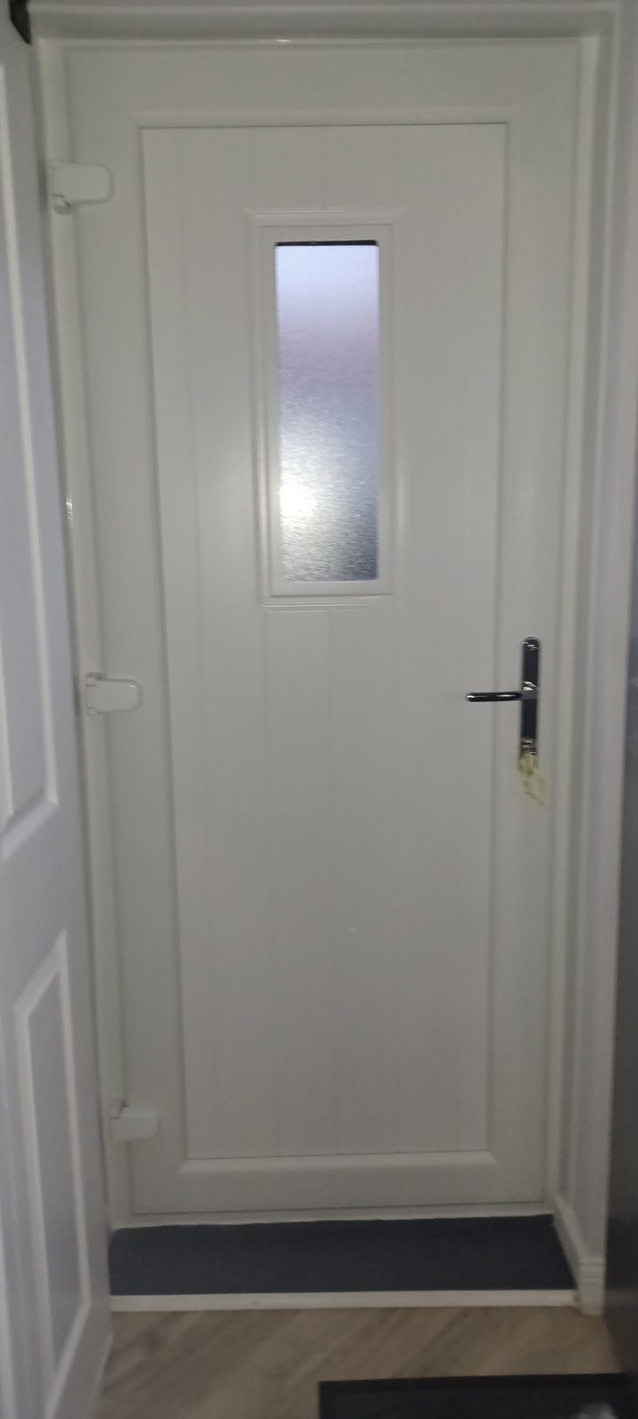 White panelled front door with a frosted glass strip, seen from inside